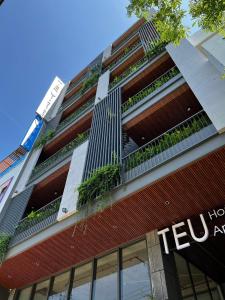 een hoog rood gebouw met planten erop bij T E U Hotel & Apartment Da Nang in Da Nang