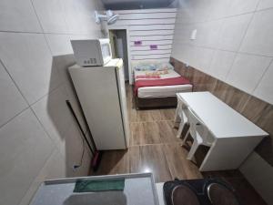 a small room with a bed and a small refrigerator at Hospedaria Cmc unidade 04 in Brasilia