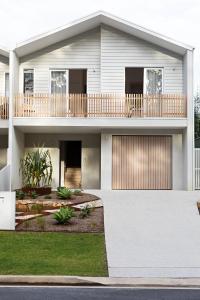 a large white house with a balcony at Aster in Narrawallee