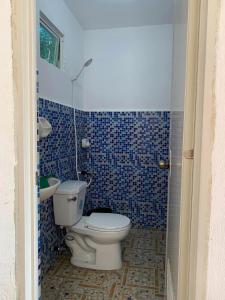 a blue tiled bathroom with a toilet and a sink at palanas white sand beach resort in Himensulan