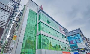 a building with glass windows in a city at Hotel O Sri Sai Guru Comforts in Bengaluru +32 photos