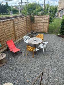 a patio with a table and chairs and a fence at Maisonnette Saint Marcel Le petit Pitolat in Saint-Marcel