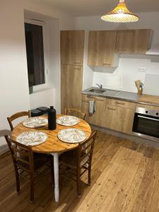 a kitchen with a wooden table with chairs and a dining room at Maisonnette Saint Marcel Le petit Pitolat in Saint-Marcel