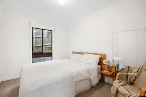 Un dormitorio blanco con una cama y una ventana. en Darlana House - BYO Linen, en Anglesea
