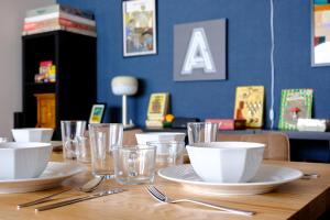 ein Holztisch mit Tellern, Schüsseln und Gläsern in der Unterkunft Board Game House Tokyo in Tokio