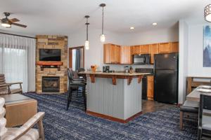 a kitchen with an island in a living room at Club Wyndham Glacier Canyon in Lake Delton