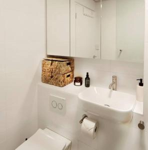 een witte badkamer met een wastafel en een toilet bij Sensational St Kilda stay at Sunset Beach Tower in Melbourne