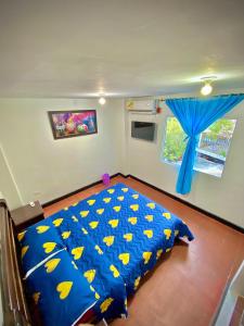 a bedroom with a bed with a blue comforter at Apartamento cerca a la playa y al centro historico in Santa Marta