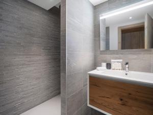 un bagno con lavandino e specchio di Appartement skis aux pieds avec 6 couchages adultes et espace bien-être - FR-1-562-82 a Courchevel Altre 8 foto
