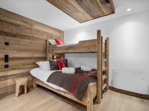 ein Schlafzimmer mit einem Etagenbett mit einer Holzwand in der Unterkunft Appartement pieds des pistes pour 7 pers avec Wifi - Saint-Martin-de-Belleville - FR-1-570-62 in Saint-Martin-de-Belleville