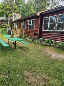a picnic table in front of a log cabin at Butler's Bay Cottage cottage in Hayward +17 photos