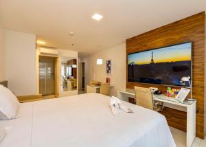 een slaapkamer met een groot bed met een bureau en een groot raam bij Charme de Paris Fusion in Brasilia