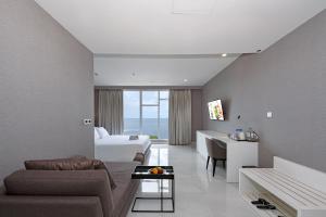a living room with a couch and a bed and a table at Grand Whiz Megamas Manado in Manado