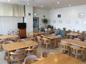 an empty classroom with wooden tables and chairs at Hotel Peace Land Ishigaki in Ishigaki Island