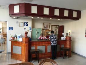 a man standing at a counter in a restaurant at Hotel Peace Land Ishigaki in Ishigaki Island