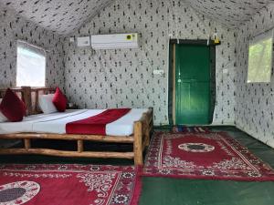 兰纳加Corbett Nature Retreat的一间卧室配有一张床,房间内有2个地毯