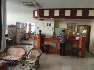 Een man aan een toonbank in een winkel. bij Hotel Peace Land Ishigaki in Ishigaki Island