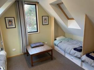 a attic room with two beds and a table at Number 8 - Castle Hill Village in Castle Hill
