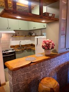 a kitchen with a counter with flowers on it at Recanto da Serenidade in Campos do Jordão