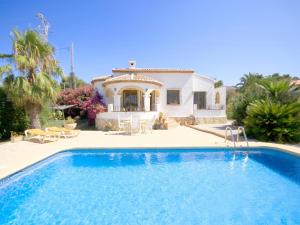 a villa with a swimming pool in front of a house at Villa Marycar in Jávea