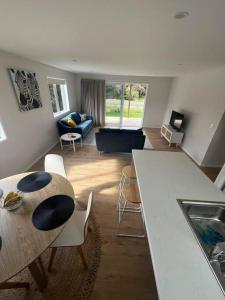 a kitchen and living room with a table and chairs at Bach At 45 in Ahipara