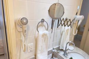een badkamer met een wastafel, een haardroger en een spiegel bij Charme de Paris Fusion in Brasilia +25 foto's