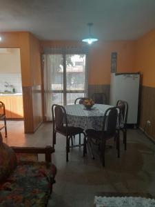a dining room with a table and chairs and a refrigerator at Casa familiar de dos plantas in Guaymallen