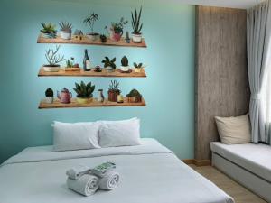 a room with a bed with plants on shelves at Beat Hotel Bangkok in Bangkok
