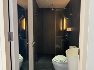 a bathroom with a shower and a toilet and a sink at Beat Hotel Bangkok in Bangkok