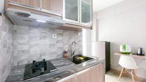 a kitchen with a sink and a counter top at Cozy Living and Homey Studio Room Cinere Resort Apartment By Travelio in Depok