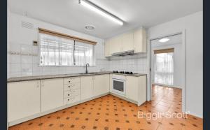 a kitchen with white cabinets and a wooden floor at Springvale Single Room for Rent in Springvale South