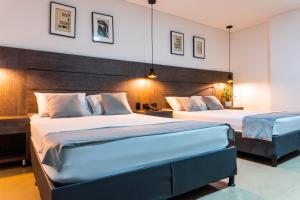 two beds in a hotel room with two beds at Hotel California City in Medellín