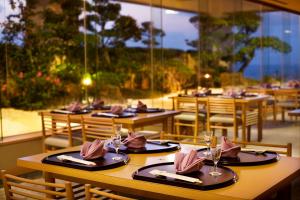 a restaurant with wooden tables with napkins and glasses on them at Renaissance Okinawa Resort in Onna
