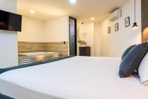 a bedroom with a bed and a tub in a bathroom at Hotel California City in Medellín