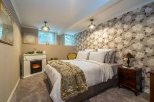 una camera con un grande letto e un camino di Sea Salt Apartment Dunedin 3 Bedrooms & Sea Views a Dunedin