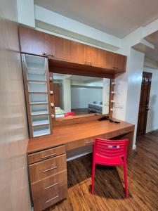 a desk with a red chair and a mirror at Lydia's Residences in Boracay +8 photos