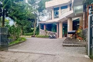 a house with a motorcycle parked in front of it at Urbanview Resort Syariah Batu Hijau Cilember Puncak in Cisarua