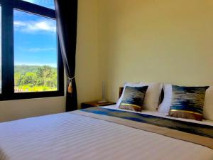 a bedroom with a large bed with a window at Hoàng Đô Hotel in Phú Quốc