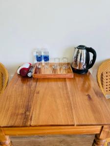 een houten tafel met glazen en een waterkoker bij Hoàng Đô Hotel in Phu Quoc +49 foto's