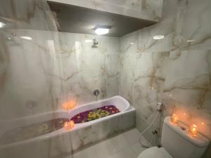 a bathroom with a bath tub with candles in it at Bali Golden Elephant Boutique Villa in Jimbaran +101 photos