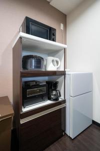 una cocina con microondas y nevera en Fancy2, en Sapporo