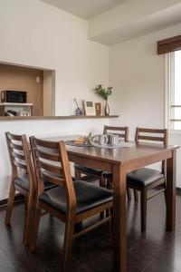 Un comedor con mesa y sillas de madera. en Fancy2, en Sapporo