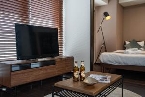 sala de estar con TV de pantalla plana y cama en Fancy2, en Sapporo