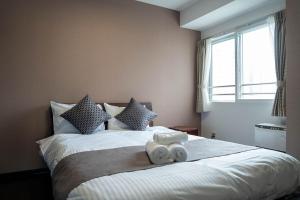 Un dormitorio con una cama con dos toallas encima. en Fancy2, en Sapporo