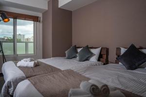 Dos camas una al lado de la otra en un dormitorio. en Fancy2, en Sapporo 37 fotos más