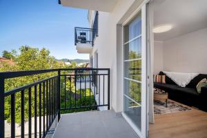 a room with a balcony with a couch at NOVERA Apartments - #C in Turčianske Teplice
