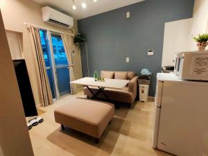 ein Wohnzimmer mit Sofa und Tisch in der Unterkunft 豆インMaMe Inn in Saitama