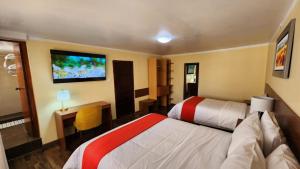 普诺Departamento INCA PALACE EXPERIENCE的一间有两张床、一张桌子和一台电视的酒店房间