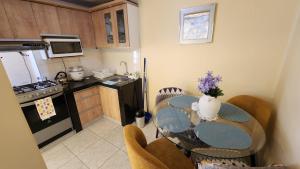 a kitchen with a table with chairs and a kitchen with a stove at Departamento INCA PALACE EXPERIENCE in Puno