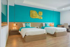 a bedroom with two beds and a blue wall at Khách Sạn X2 Vibe Việt Trì in Làng Tiên Cát